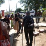 22.-Rumbo a los ómnibus, entre ellos, asistido por una monja, el anciano que sufrió un desmayo durante la misa. Foto. AMD